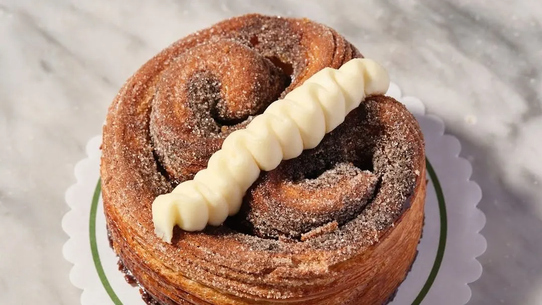 A glazed swirl pastry on a marble counter at Cresci