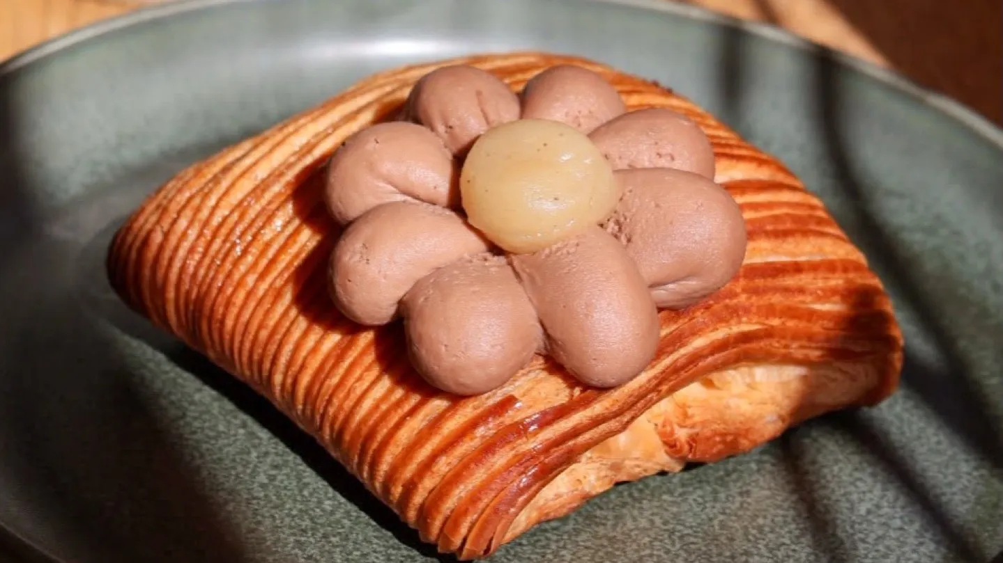 A laminated pastry topped with cream and hazelnuts at Love