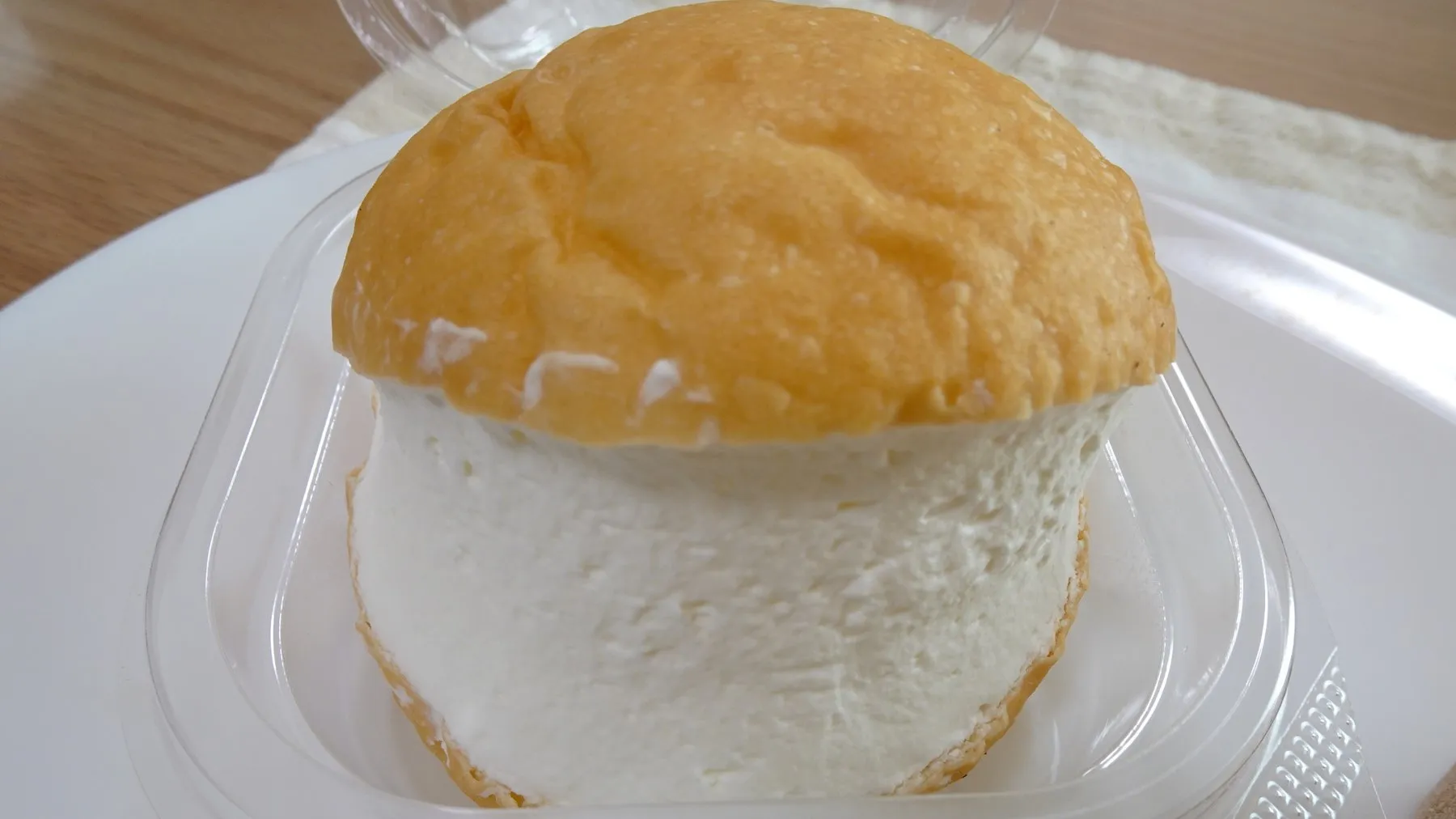 A round maritozzo filled with a thick layer of cream