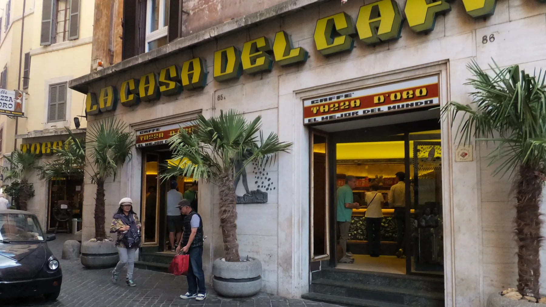 The yellow sign of La Casa del Caffè Tazza d'Oro over its doors on Via degli Orfani