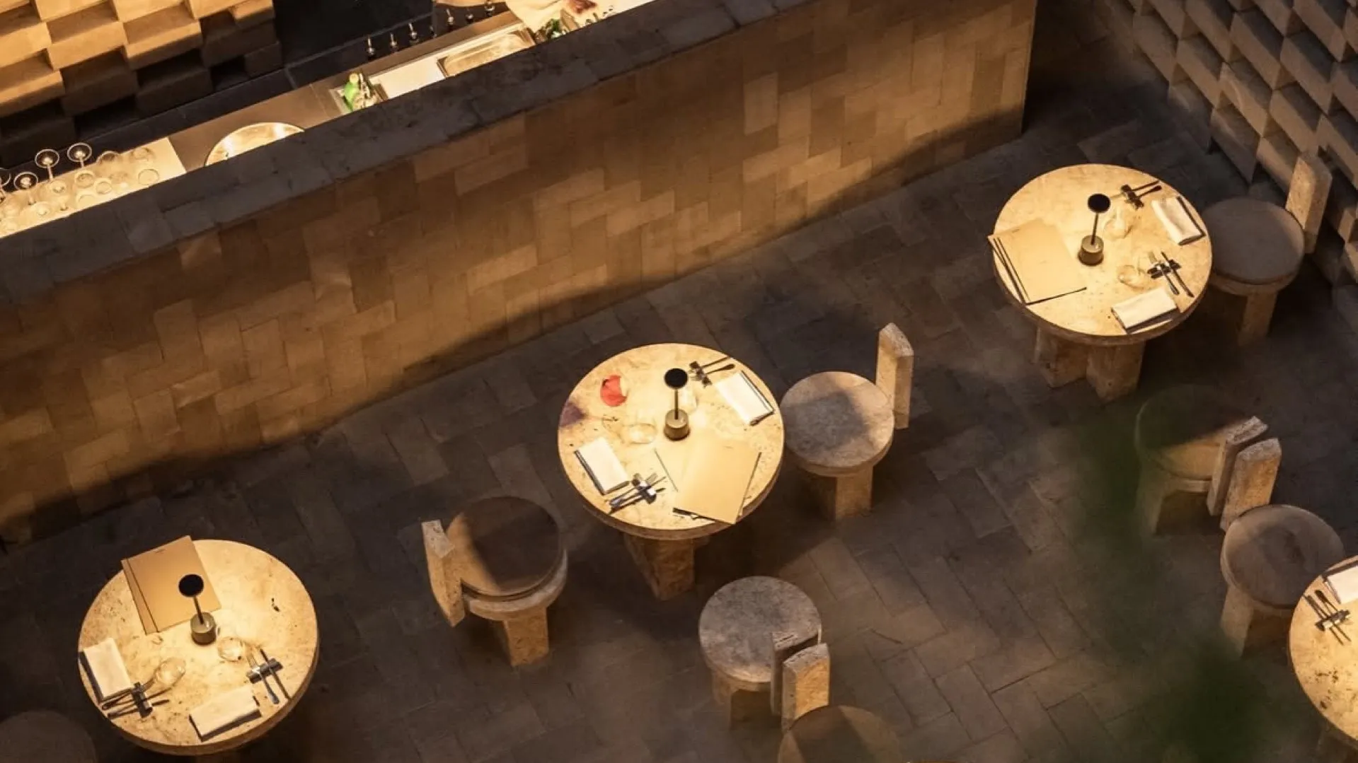 The room at Nomos, stone tables and a travertine counter seen from above