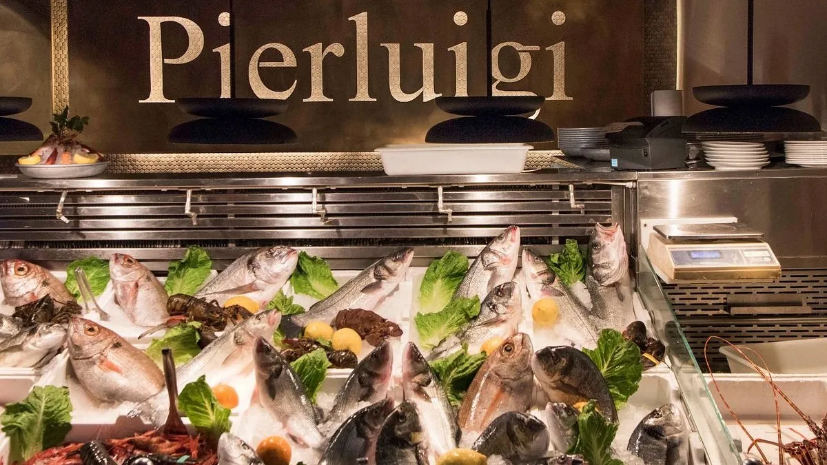 The Pierluigi name in brass above the counter of fresh fish on ice