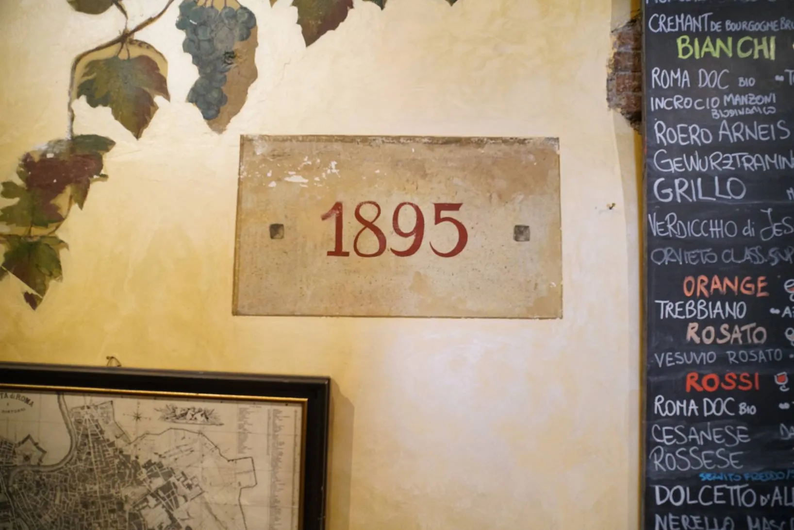 inside Ai Tre Scalini, the painted "1895" on the wall beside the wine board